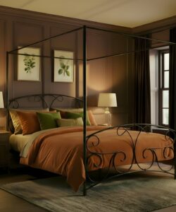 lyra iron bed. Four poster in a cosy room.